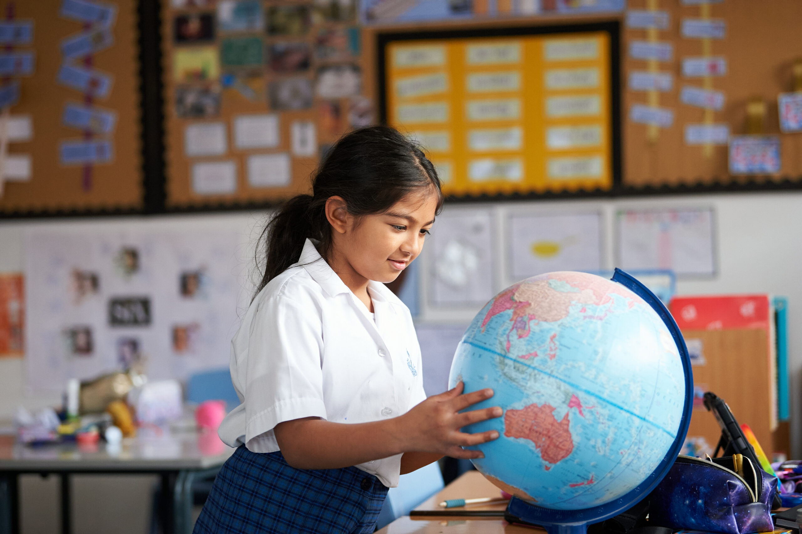 Girl looking at a globe at Bury Grammar School scaled