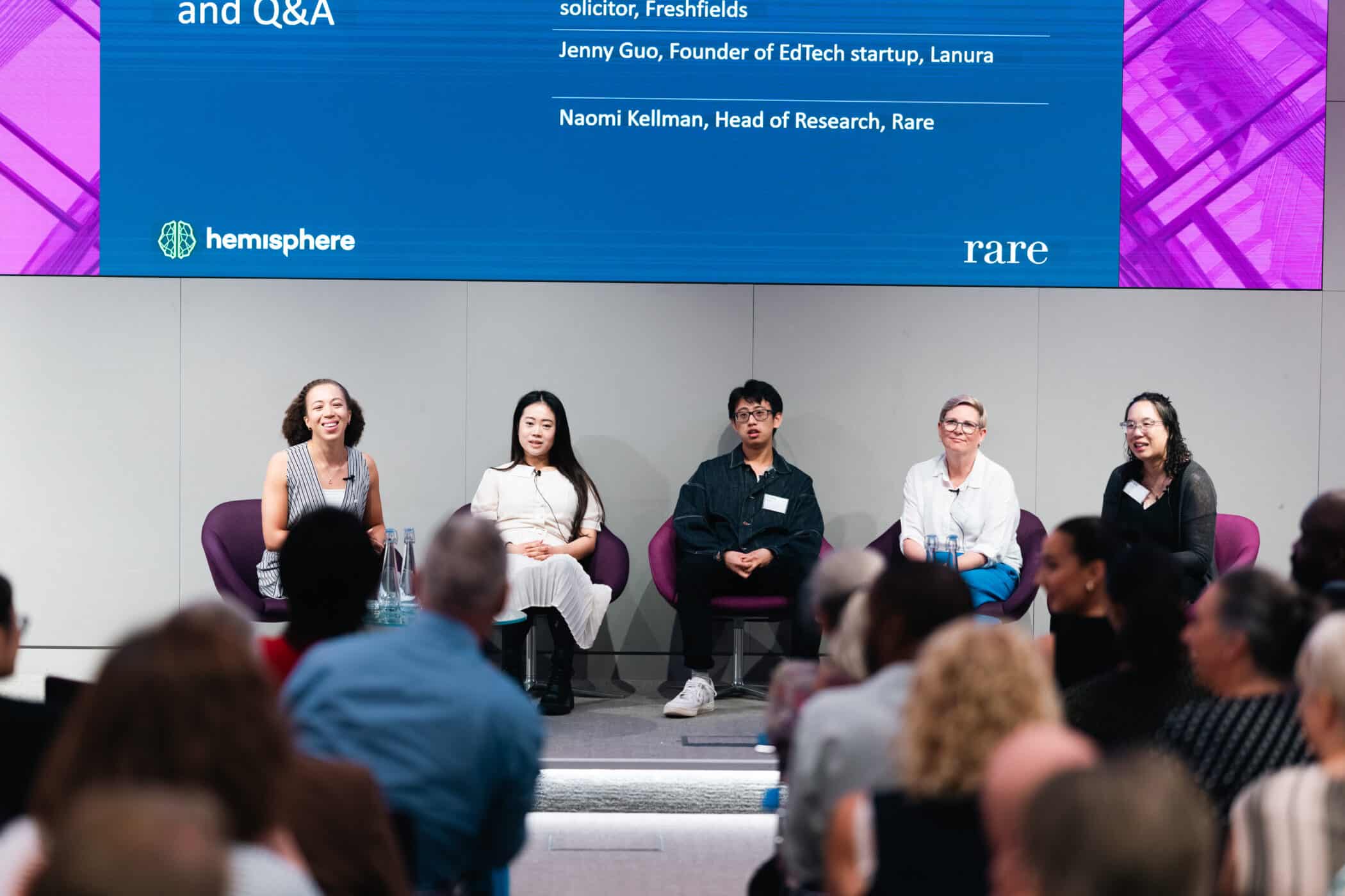 Five panelists sit on stage during a Hemisphere and Rare event, speaking to an engaged audience about education, equity, and belonging.